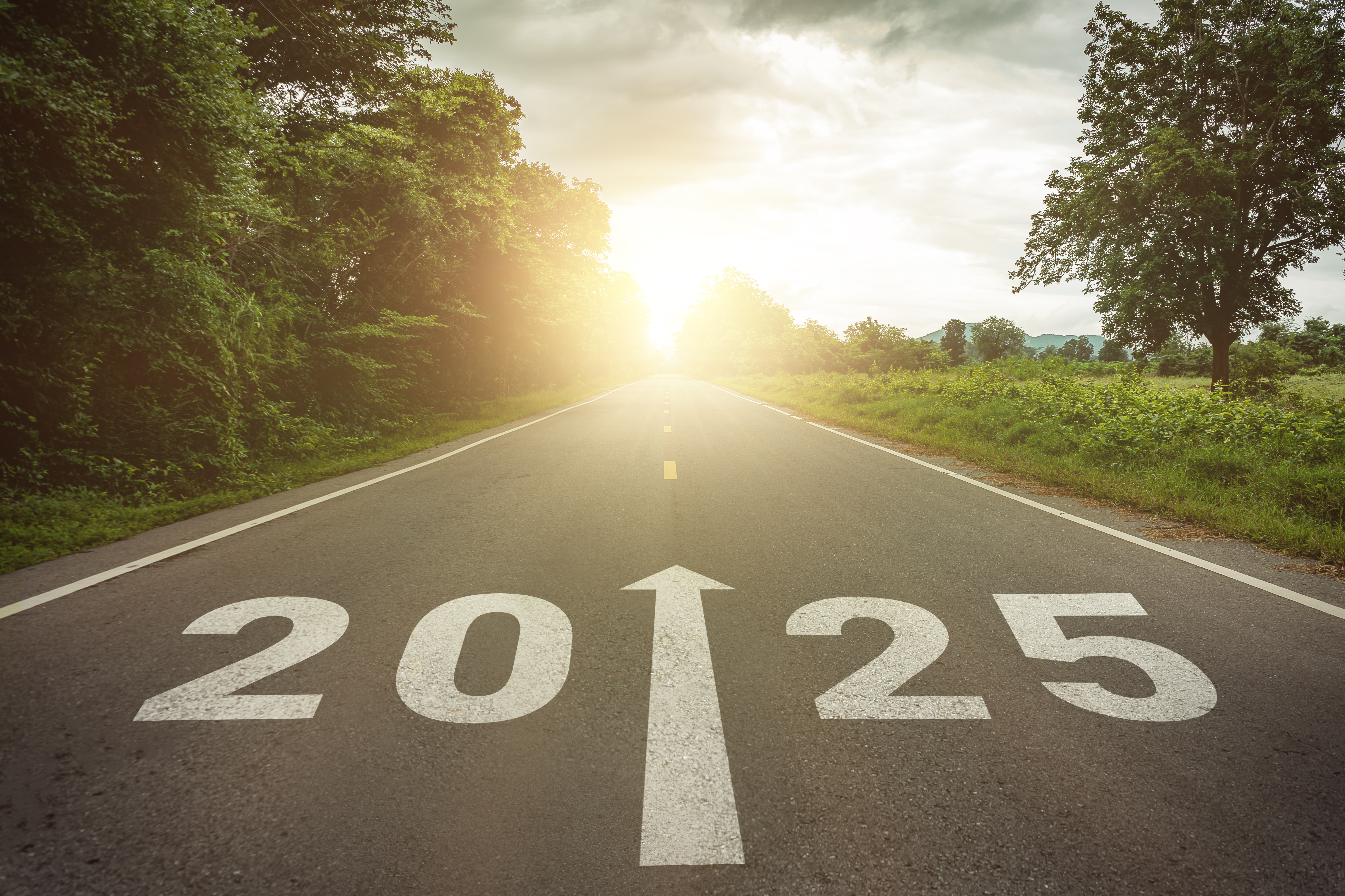 New year 2025 or straightforward concept. Text 2025 written on the road in the middle of asphalt road at sunset. 