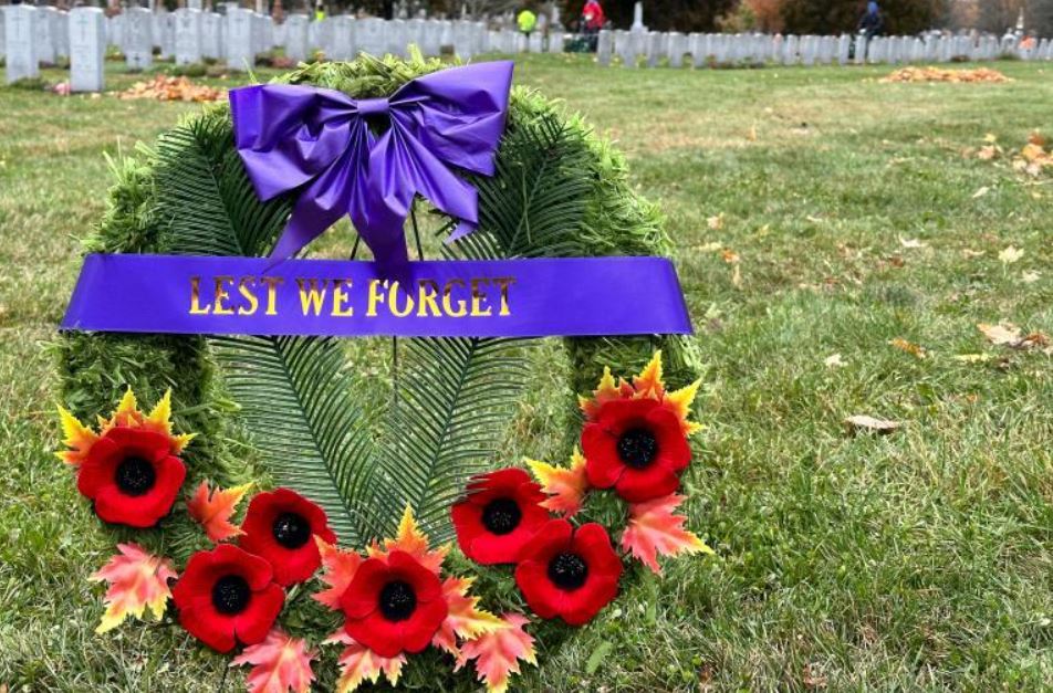 day of tribute wreath with workers behind them