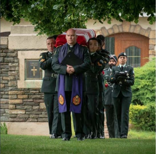 Military Chaplain leading a procession with a military honour guard